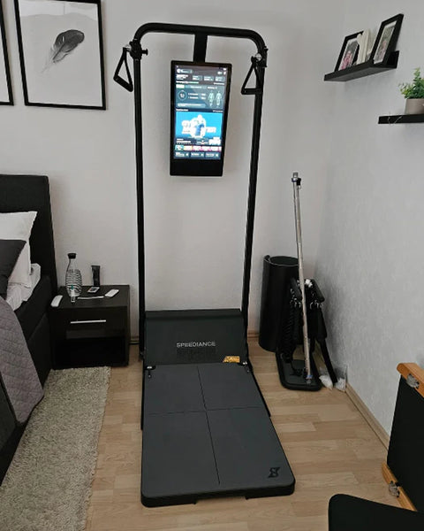 Un Gym Monster dans une chambre, près d’un lit et d’étagères