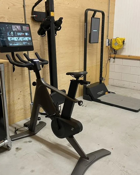 Un Gym Monster dans un garage aménagé, à côté d’un vélo d’appartement