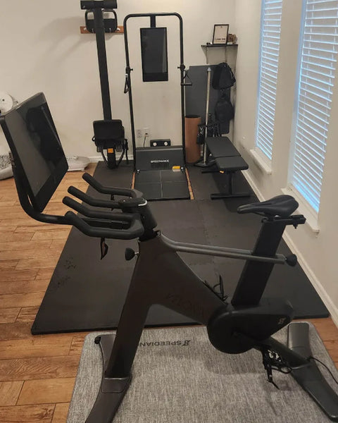Un Gym Monster dans une salle de sport à domicile avec vélo d’appartement et banc