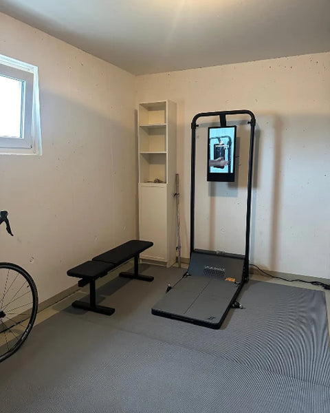 Un Gym Monster dans une pièce lumineuse avec un banc et un vélo