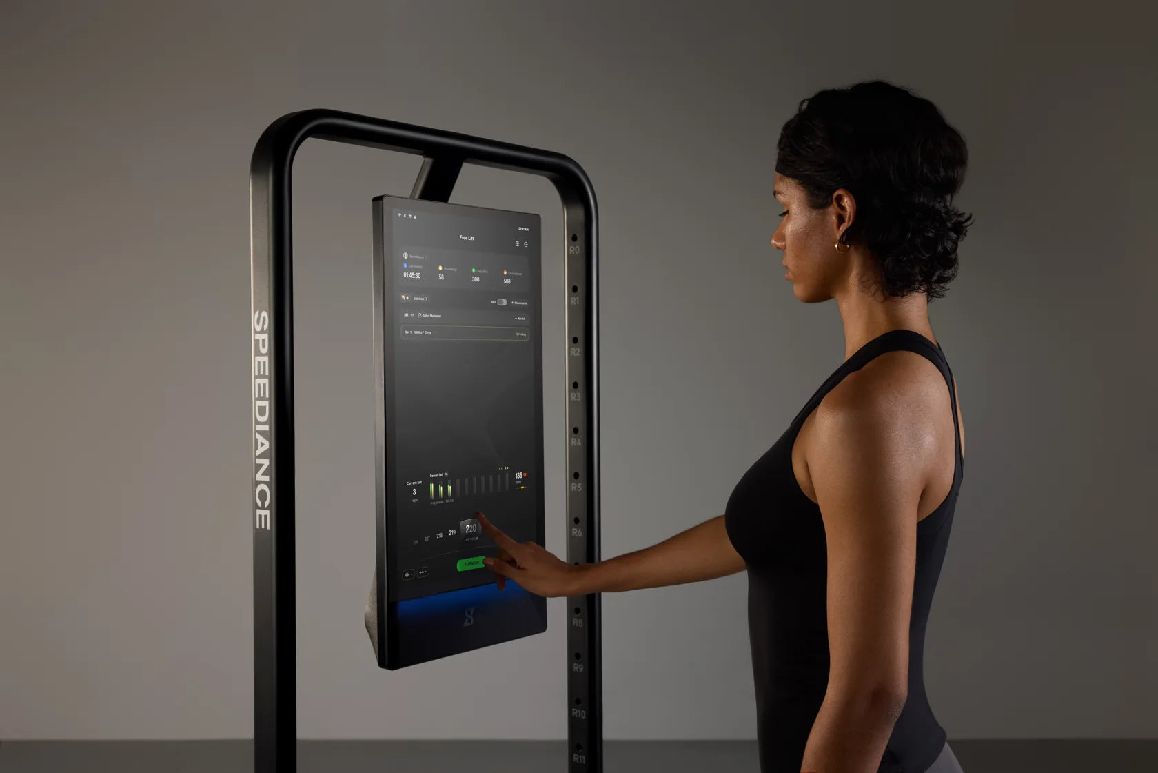 Une femme règle la résistance numérique sur l'écran tactile du Gym Monster 3